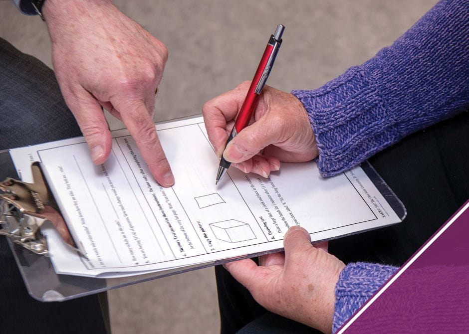 Close-up of a patient 's hands filling out the SAGE test