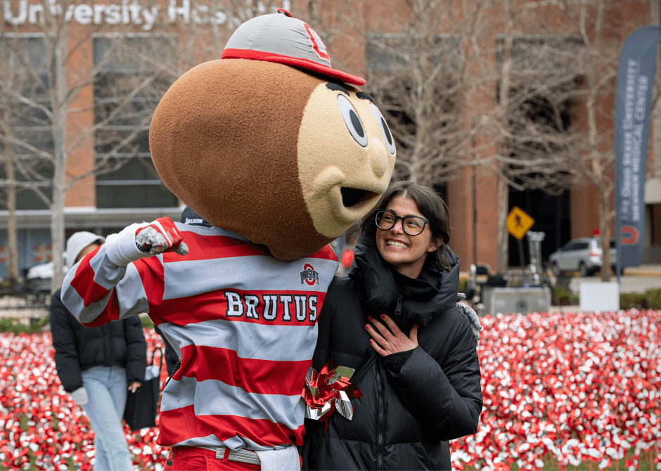 Sarah Whitley poses with Brutus Buckeye at the pinwheel planting ceremony